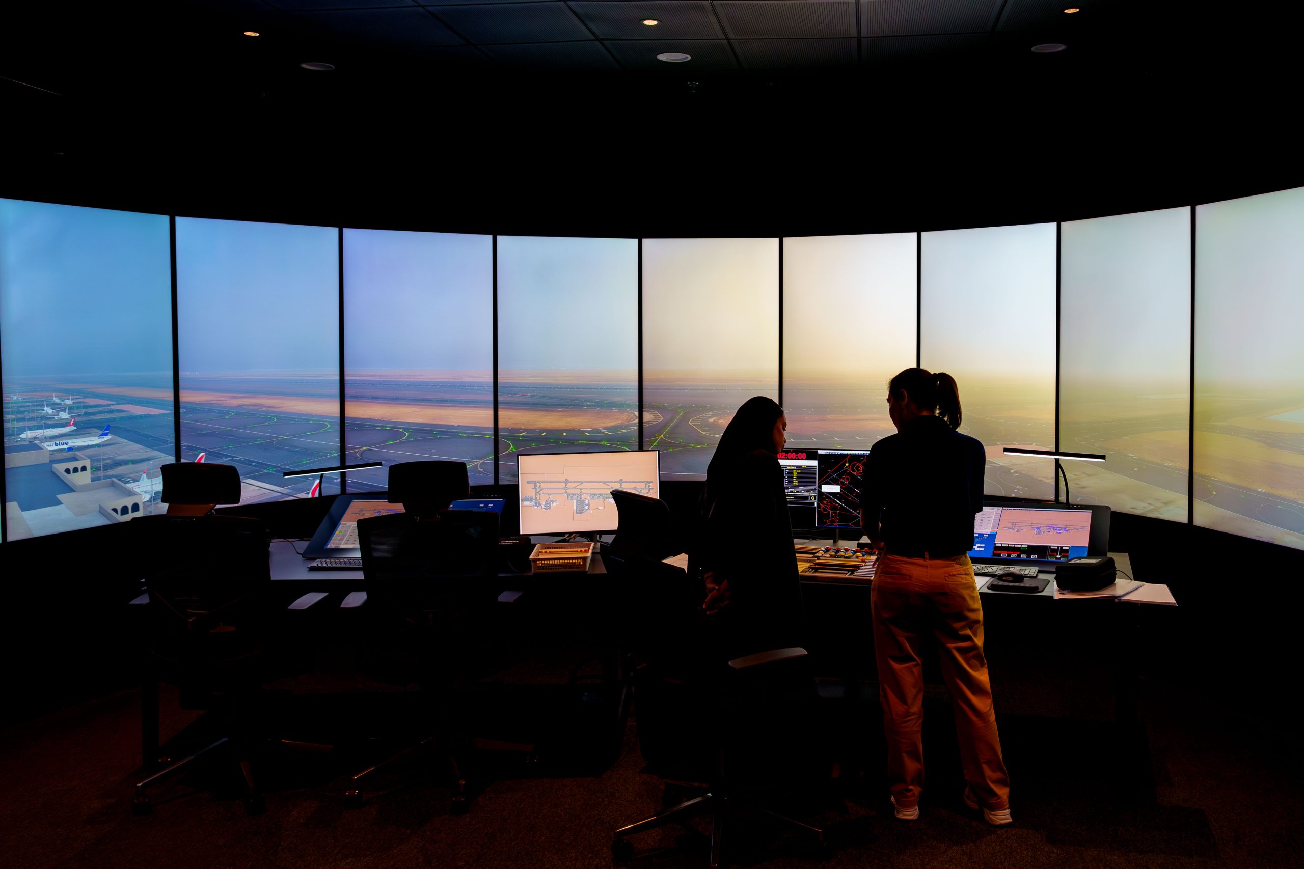 Two women at a screen inside the air traffic control simulator.